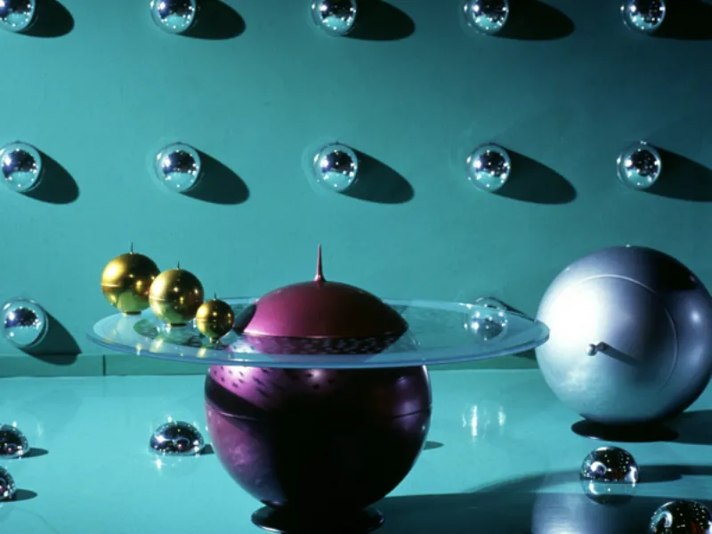 tavolino design: sfera viola con pannello circolare in vetro trasparente, tre sfere dorate, emisferi decorativi a parete