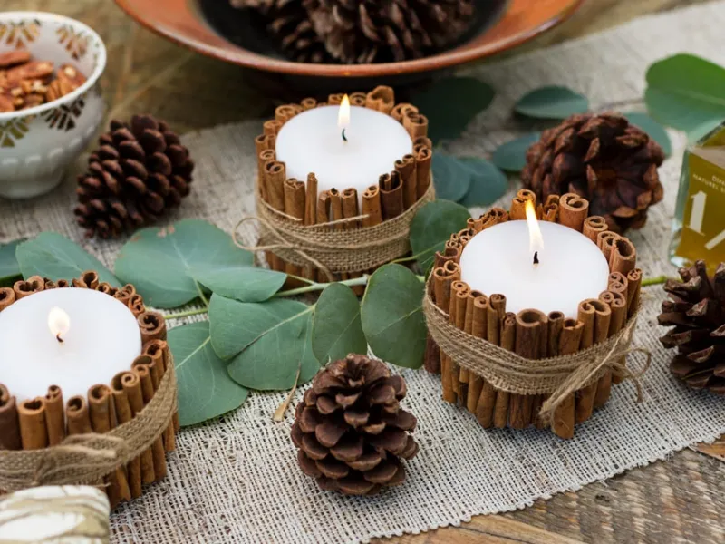 Candele per decoro tavola di Natale con cannella e pigne
