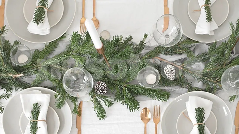 Tavola di Natale bianca e verde con posate dorate