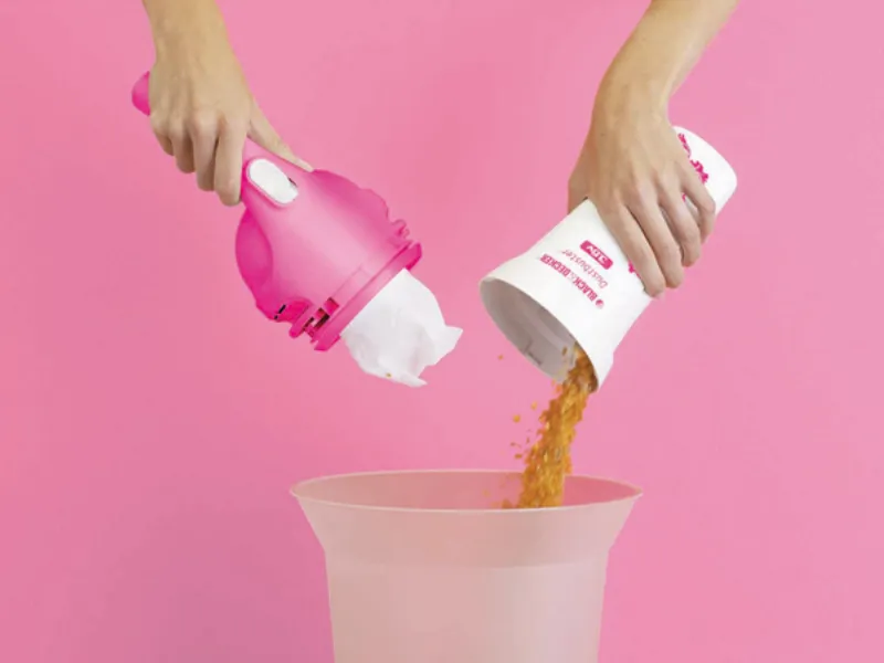 polvere svuotata in cestino da aspirapolvere rosa  