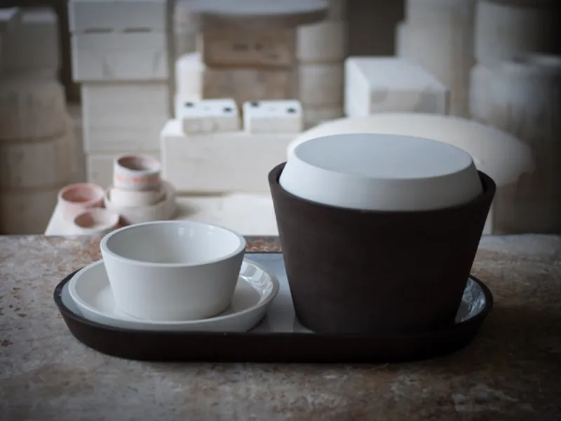 ciotola con sotto piatto in ceramica bianca, insalatiera in ceramica nera su vassoio in ceramica nero e bianco