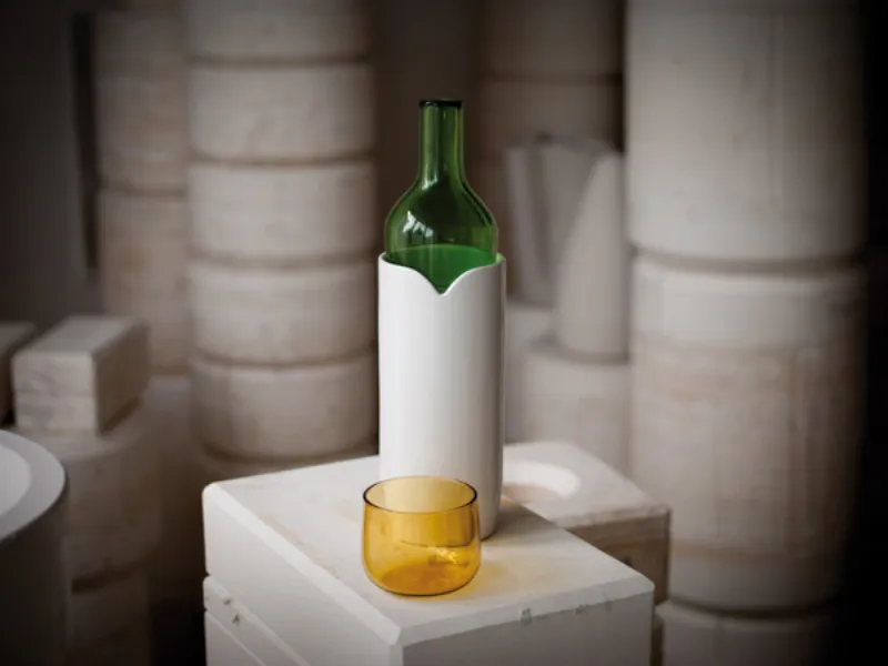 caraffa in vetro verde con contenitore in ceramica bianco e bicchiere in vetro giallo