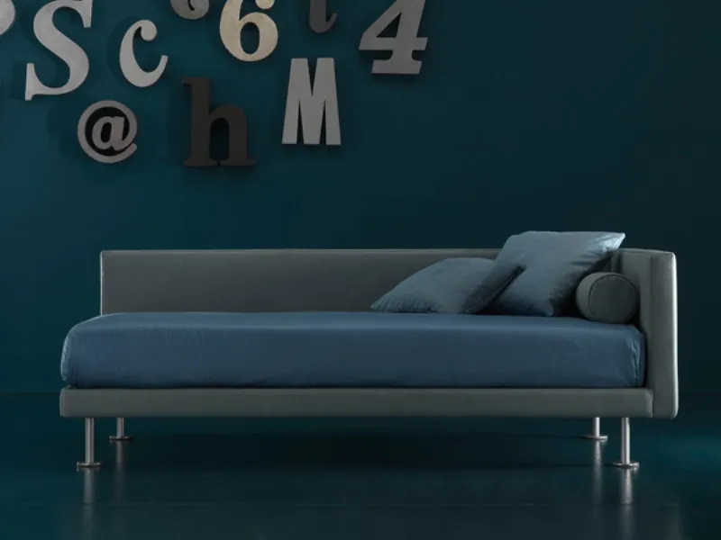 letto singolo e cuscini verde oliva con copri materasso blu pavone, lettere e cifre decorative alla parete
