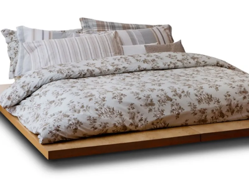 letto matrimoniale con copripiumino floreale sui toni del rosa e verde oliva, cuscini a righe abbinati