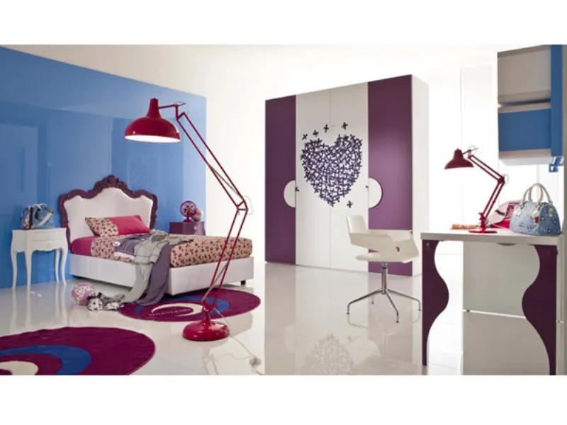 cameretta per bambina con letto matrimoniale con testiera bordata di viola, lampada da terra a stelo e da tavolo melanzana, armadio con ante e cassetti bianchi e viola e grafica a cuore