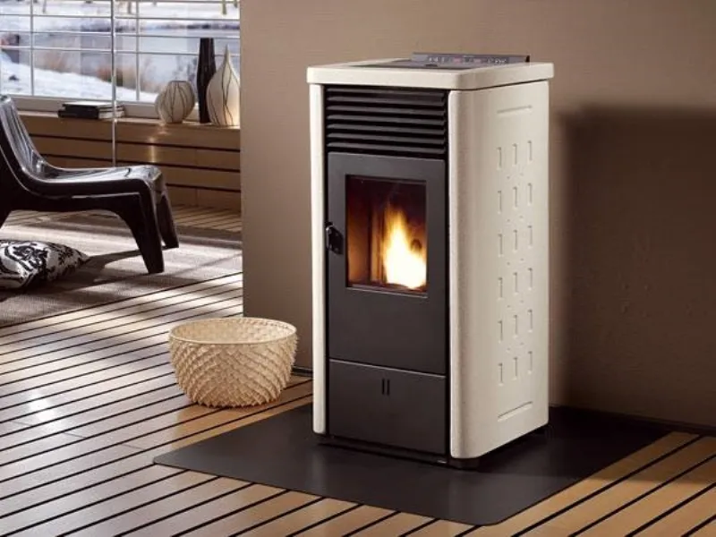 stufa a pellet in funzione con rivestimento bianco panna, pavimento a liste in legno e cesta