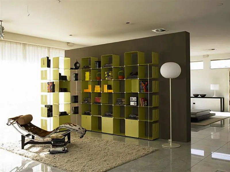 libreria in metallo verde mela, lampada da terra con paralume ovoidale bianco, tappeto in peo beige, chaise-longue
