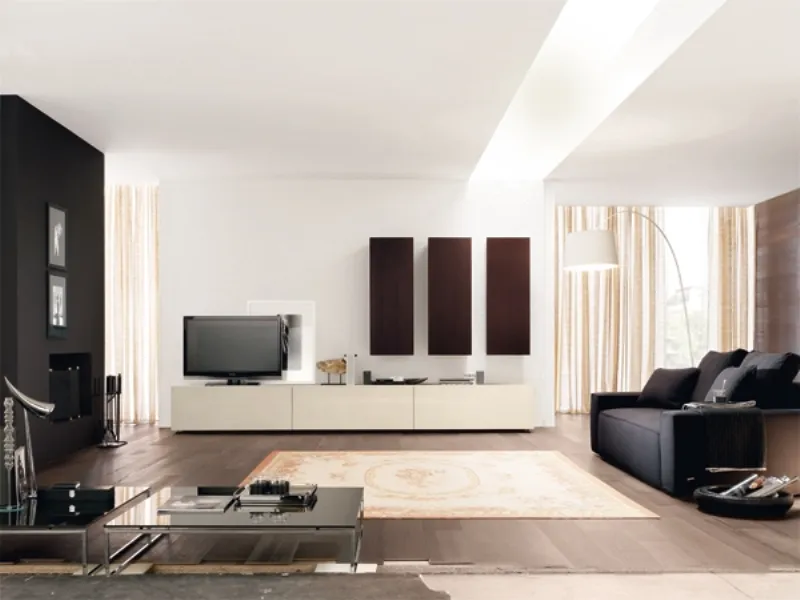 salotto con pavimento i parquet scuro, mobile tv panna, tre armadi rettangolari verticali neri, divano nero sulla destra