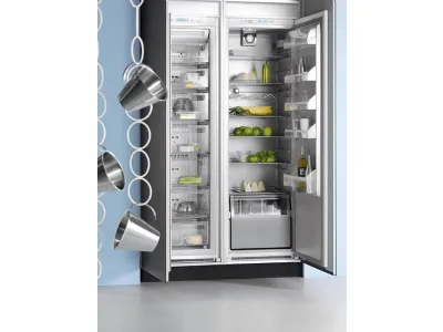 frigo a doppia porta aperto con ananas, lime, bottiglie e contenitori, tre pentolini sospesi su una catena