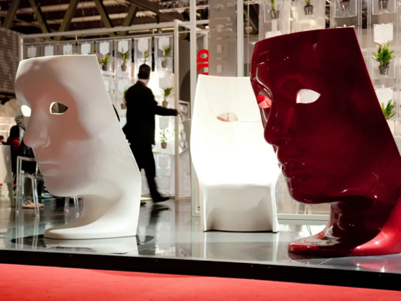 tre sedute a forma di maschera bianche e rosse in spazio espositivo