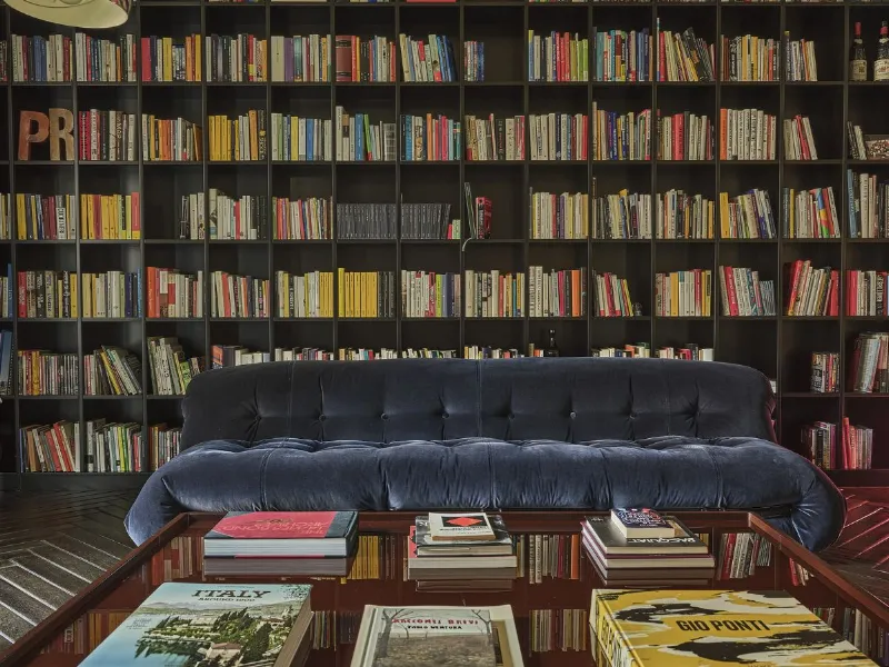 La libreria su misura e i divani ribadiscono la matrice anni Settanta del progetto