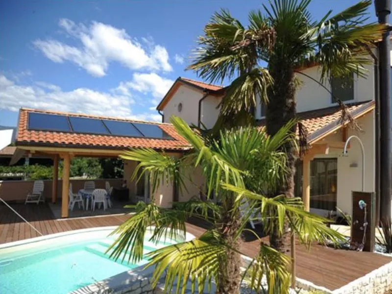 casa con piscina, pannelli solari e palme