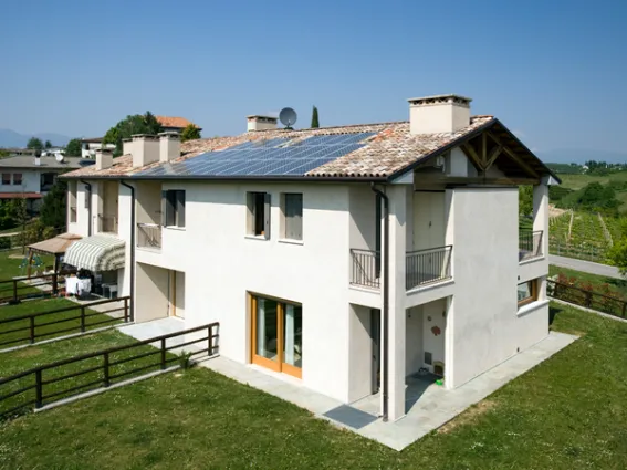 Pannelli fotovoltaici sul tetto di casa con giardino