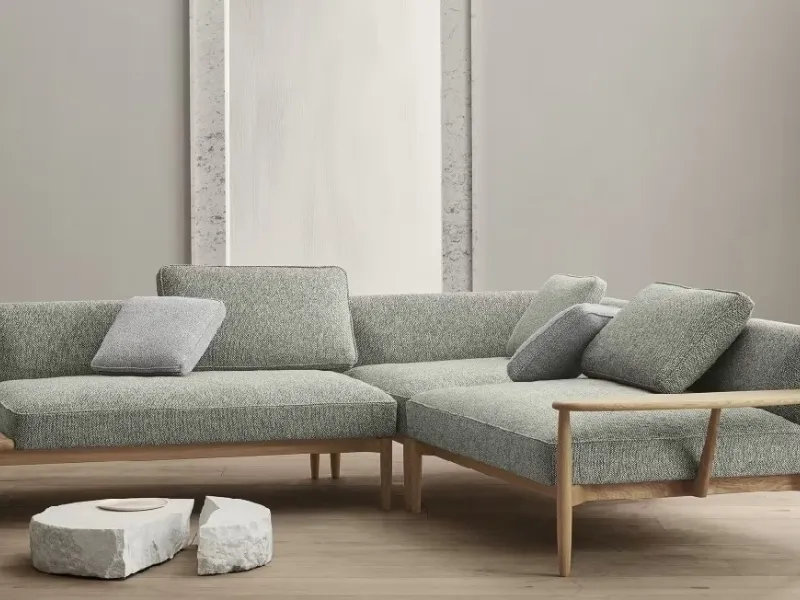 Nel divano angolare E300 Embrace Sofa di Carl Hansen & Son la struttura di legno a lato diventa ripiano-tavolino