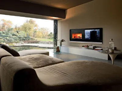 zona living con divani in suede marrone e camino da parete con schermo lcd