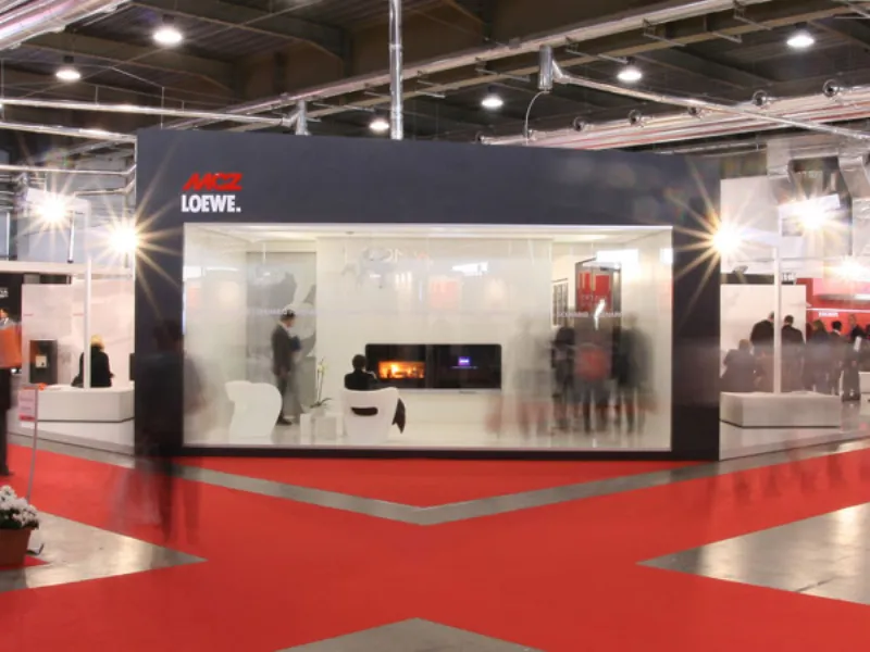 stand espositivo in fiera con camino e schermo lcd, tappeto rosso