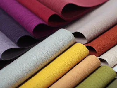 tessuti piegati multicolore, in primo piano colori grigio chiaro, giallo, arancio chiaro e verde