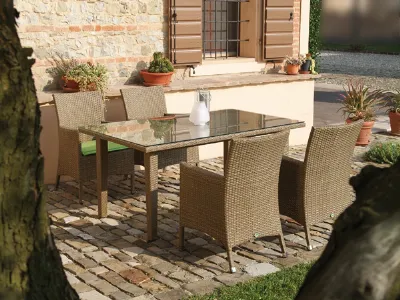 tavolo da esterno in rattan con lastra in vetro e quattro sedie abbinate, piccolo vaso bianco