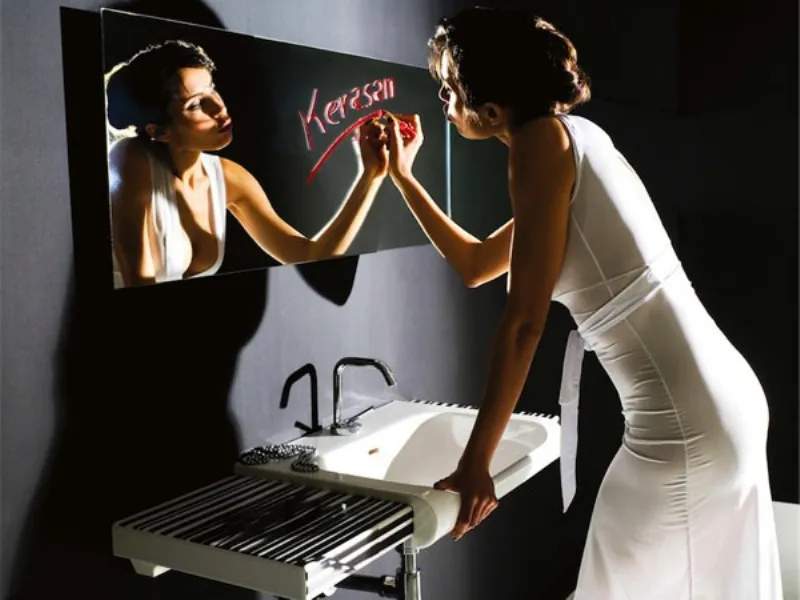 donna con vestito lungo bianco che scrive con rossetto rosso su specchio