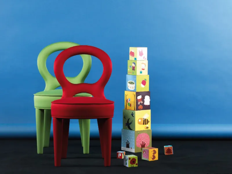 due sedie imbottite rossa e verde mela con cubi per bambini impilati
