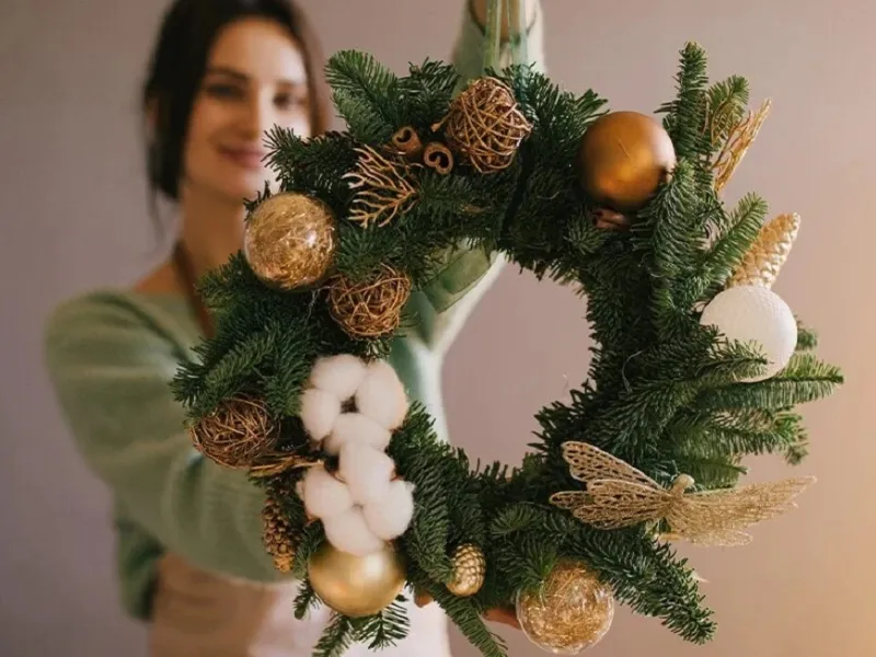 Una ghirlanda fai da te con materiali riciclati per la porta di Natale