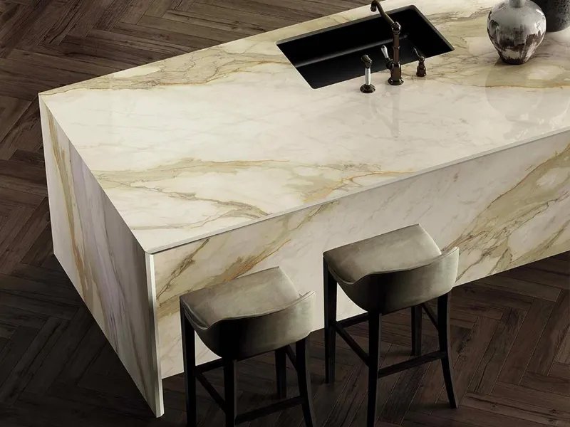 Infinity propone il pregiato gres effetto marmo Calacatta Hermitage con base avorio e venature dorate, grigie e arancioni