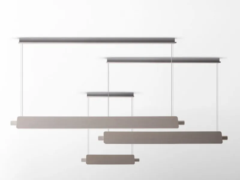 Lampadari essenziali composti da barre in legno sorrette da cavi d'acciaio.