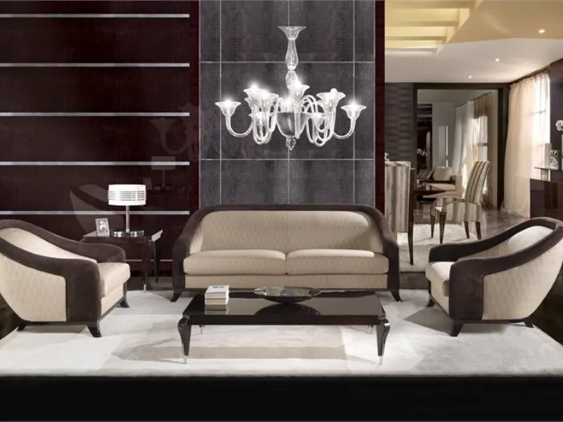 salotto con divani color panna con bordi in velluto marrone, tavolino nero e lampadario in vetro trasparente