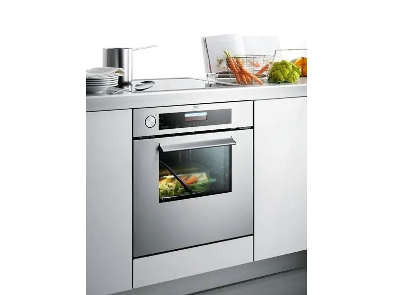 forno in acciaio in mobile cucina, ricettario e verdure